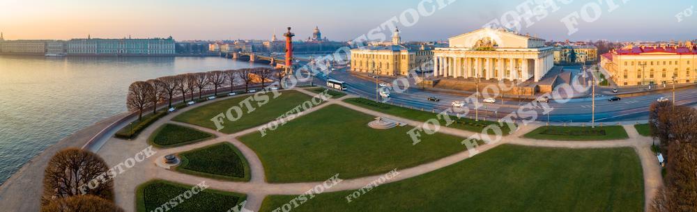 Панорамная фотография Васильевского острова в Санкт-Петербурге, снятая с высоты птичьего полета ранним утром. На снимке видны здание биржи, ростральные колонны, Дворцовый мост, река Нева и Эрмитаж. Съемка с дрона позволяет оценить архитектурные ансамбли исторического центра города, красоту набережных и отражения утреннего света в воде Невы. Фотография подчеркивает атмосферу спокойного утра, величие городской архитектуры и гармоничное сочетание рек, мостов и исторических зданий. Этот снимок идеально подходит для туристических публикаций, фотостоков, оформления интерьеров, рекламы и материалов о путешествиях по Санкт-Петербургу.